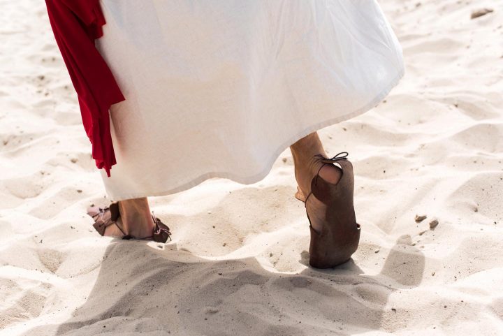 The feet of Jesus walking in the desert sand